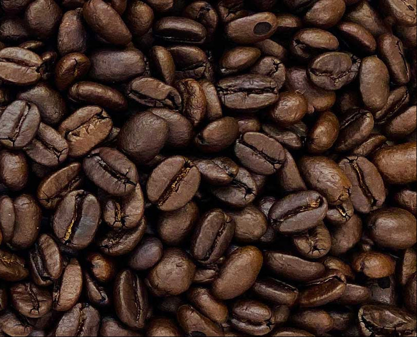 Three different grades of coffee beans arranged in a gradient from light to dark.