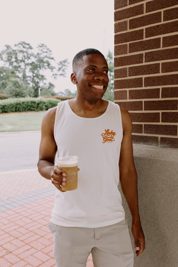 Man holding a coffee cup outdoors near a brick building