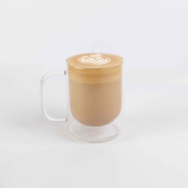 Glass mug with a latte art design on a white background