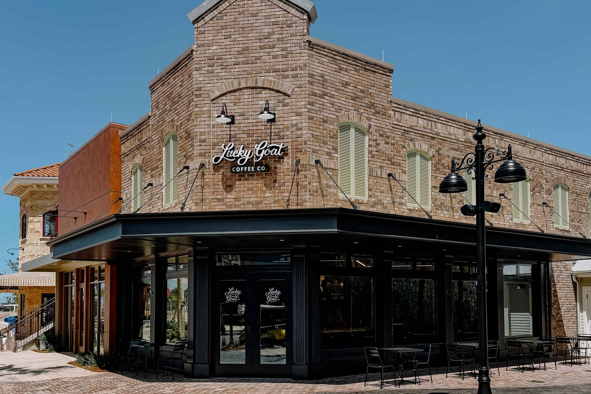 Brick building with 'Lucky Goat Coffee Co.' sign on a clear day