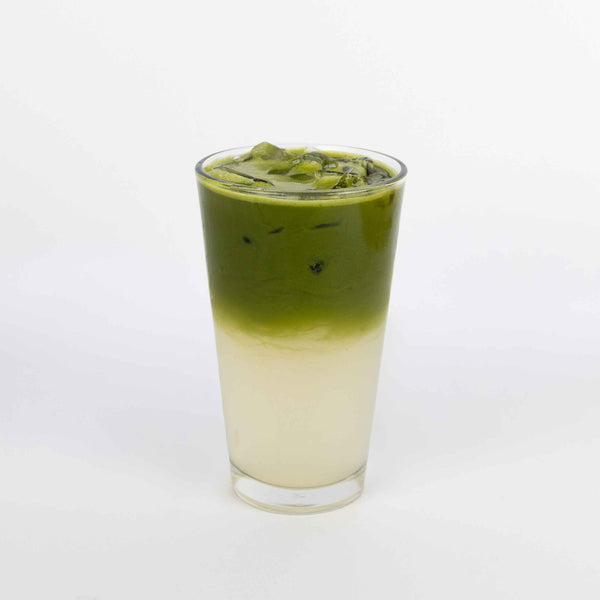 Green iced drink in a glass on a white background
