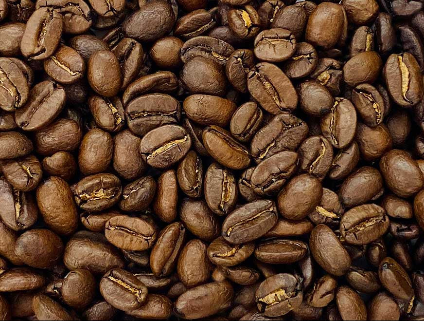 Three different grades of coffee beans arranged in a gradient from light to dark.