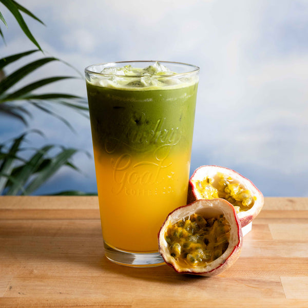 Passionfruit Matcha Lemonade on a table with a cut open passionfruit